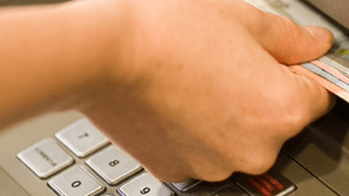 Hand zieht Scheine aus dem Geldautomaten