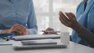 Schmuckbild: Medizinisches Personal, davor liegen Dokumente