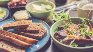 Mehrere Teller mit Brot und anderen Ballaststoff-reichen Lebensmitteln
