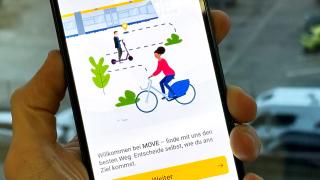 Hand hält Smartphone mit dem Startbildschirm der Shared Mobility App "MOVE"