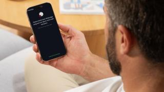 Ein Mann hält ein Smartphone in der Hand, auf dessen Disyplay in weißer Schrift auf schwarzem Hintergrund steht: "Dieses Konto kann WhatsApp aufgrund von Spam nicht mehr benutzen. Chats sind noch auf diesem Gerät."