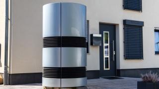 Eine moderne Luft-Wasser-Wärmepumpe vor einem Einfamilienhaus