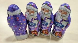 Vier Milka-Schokoweihnachtsmänner nebeneinander
