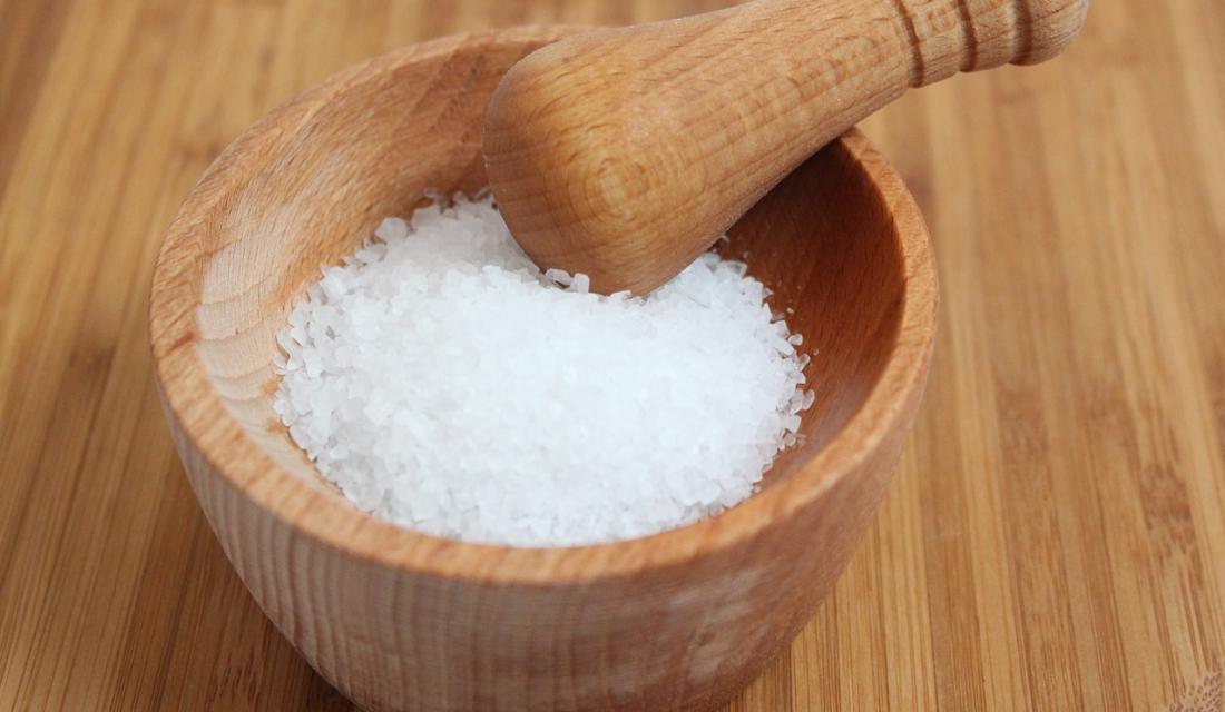 Grobkörniges Salz in einem Mörser mit Stößel