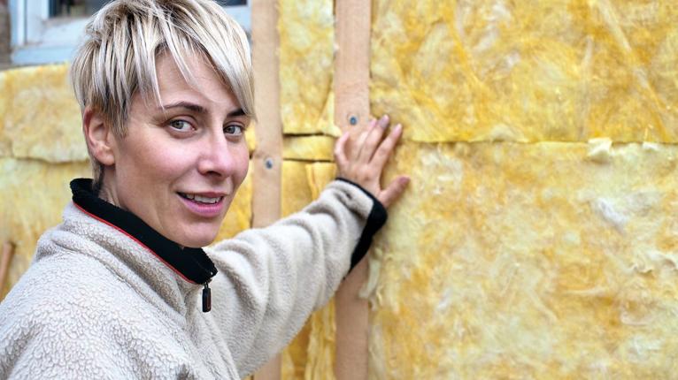 Junge Frau vor frisch gedämmter Wand