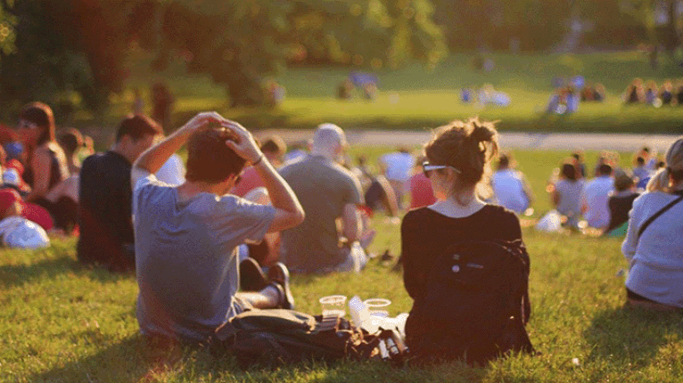Junge Menschen in Abendsonne auf Wiese