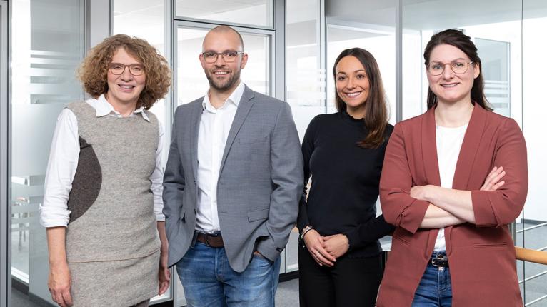 Vier Mitarbeitende in einem Büro