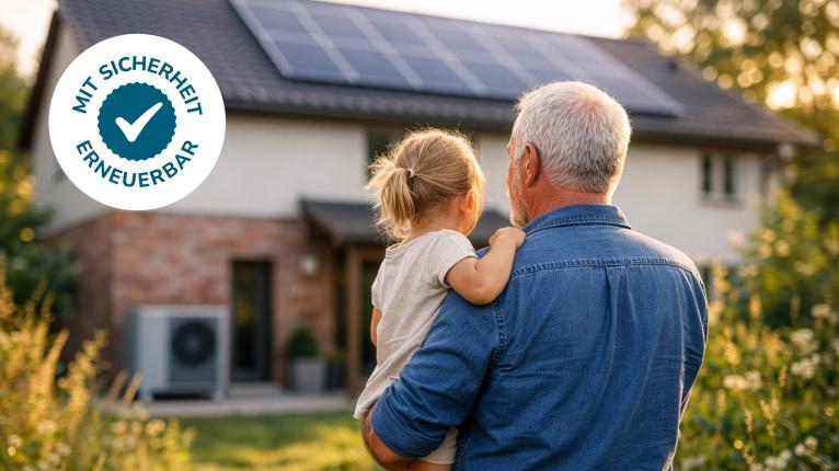 Mann mit Kind auf dem Arm blickt auf Haus mit Wärmepumpe und Photovoltaikanlage